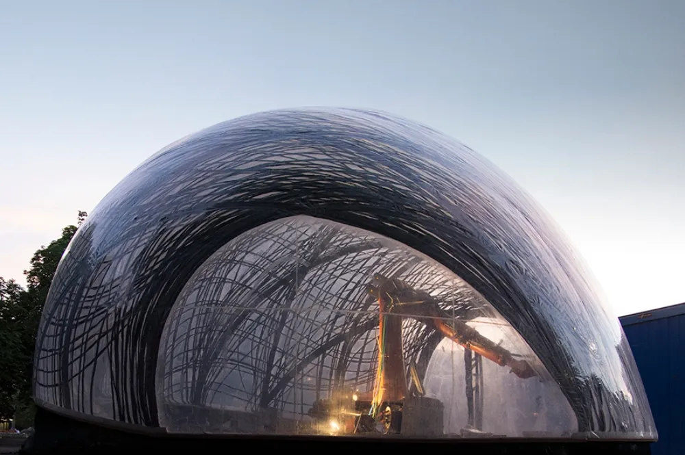 Robotic arm inside a bubble applying carbon fiber