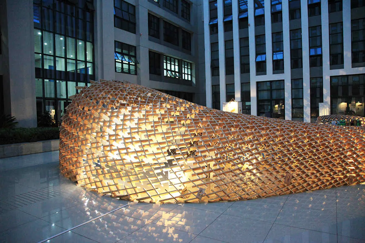 Reciprocal Frame Pavilion from the outside with lights at night. Developed by Nathan Melenbrink, Samo Pedersen and Shibu Raman. University of Nottingham, Ningbo, China.